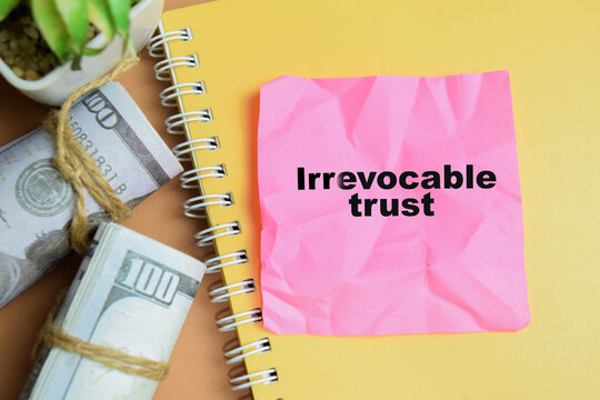 Concept of irrevocable trust write on sticky notes isolated on table.