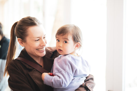 Happy auntie carrying her curious toddler