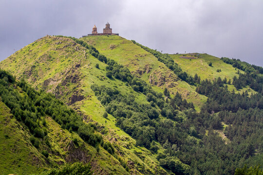 Gergeti Trinity Church atop a lush green hill in Georgia