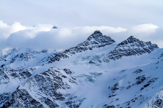 Dramatic snow covered mountains under a cloudy sky