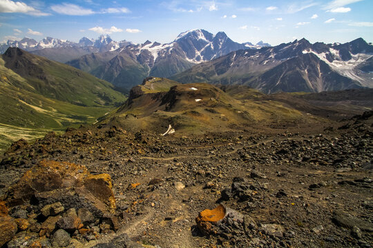 Rocky alpine terrain overlooking a snow capped mountain valley