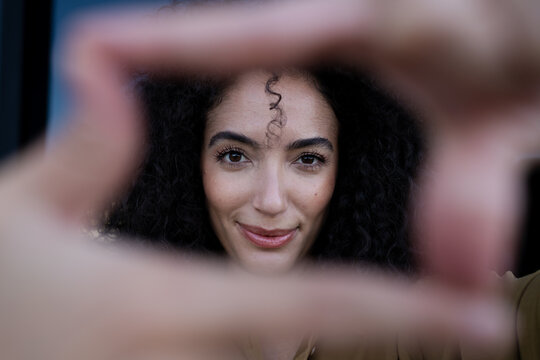 Close-up portrait of a smiling woman with curly hair framing her face