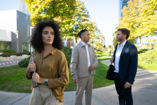 Business white professionals conversing outdoors in urban park