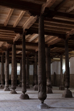Carved wooden columns inside Juma Mosque in Khiva, Uzbekistan. Ancient hypostyle hall with ornate pillar carvings and timber ceiling, ideal for travel and heritage publications.