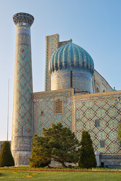 Sher-Dor Madrasah at Registan Square in Samarkand featuring turquoise dome and minaret with intricate tilework. Ideal for travel guides, tourism brochures, and cultural heritage publications.