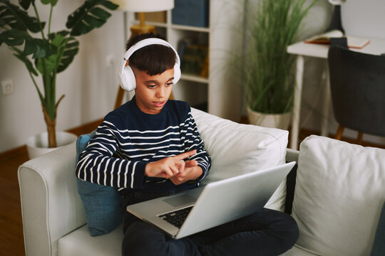 Boy in headphones learning sign language using laptop