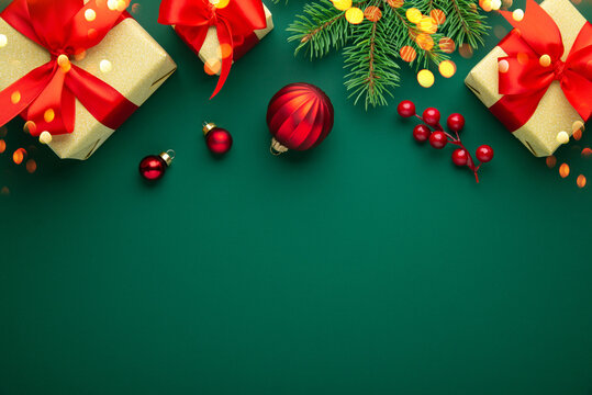 Green Christmas and Happy New Year holiday background with gift boxes, red ribbon bows and festive ornaments, flat lay with copy space. Greeting card.
