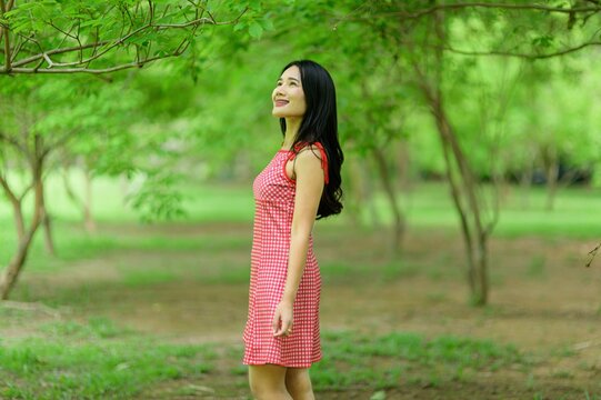 Woman in Red Dress Enjoying Nature in Beautiful Flower Garden