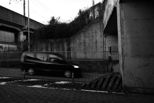 高架下を走る車とコンクリートの壁面