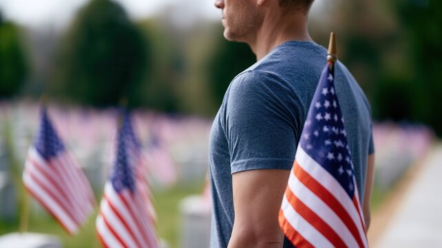 Man standing respectfully at military cemetery during memorial day honoring fallen with american flags soldiers
