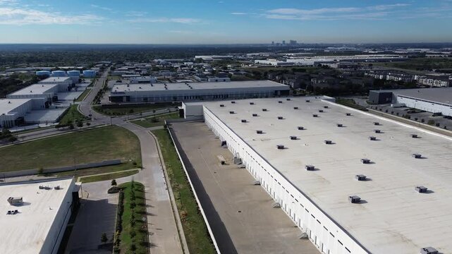 White membrane roofs align along commercial shipping avenues along Northeast Loop. Spacious cargo docks adjoin turf borders, wide vehicle turnarounds, service roads, Haltom City, Texas