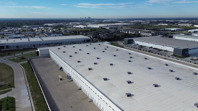 Paved distribution yard borders manicured property line Loop industrial enterprise corridors along Northeast Loop. Vast concrete aprons support semi trailers, heavy shipping, Haltom City, Texas