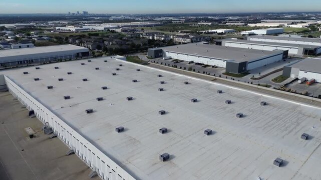 Massive fulfillment complexes flank regional trade passages along Northeast Loop. Wide paved aprons complement rear loading slips, asphalt transit drives, retention ponds, Haltom City, Texas