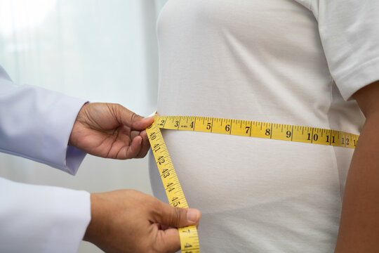 Asian woman with fat belly big size overweight and obesity with measure tape.