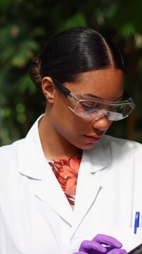 Female botanist studying plants using digital tablet