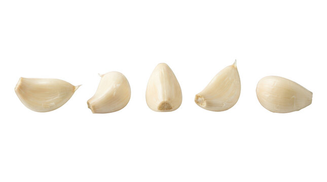 Five peeled garlic cloves arranged in a row isolated on transparent background