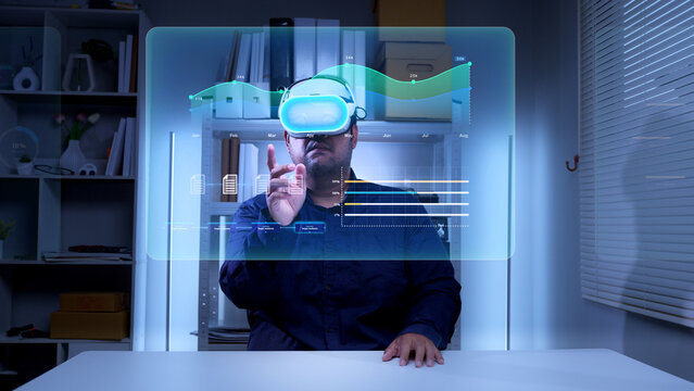 Businessman wearing virtual reality headset interacting with digital interface showing analytical data in modern office environment