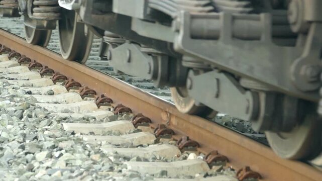 Close up of an old diesel locomotive train wheels moving slowly on railroad tracks entering the frame, vintage railway transit engine wheels rolling on steel rails, audio included
