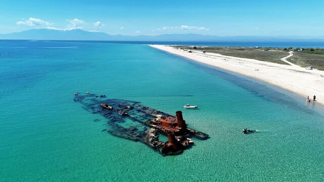 Top down aerial close up of broken shipwreck hull exposing rusted structural ribs and flooded cargo hold