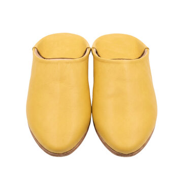 Pair of yellow leather Moroccan babouche slippers with pointed toes and folded down heels, backless traditional slip-on shoes, isolated on transparent background
