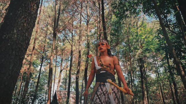 Wide Shot of a Traditional Indonesian Warrior Archer in a Pine Forest