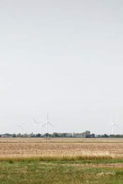 Wind Farm Turbines on Flat Rural Landscape Overcast Sky Renewable Energy and Sustainable Farming Scene