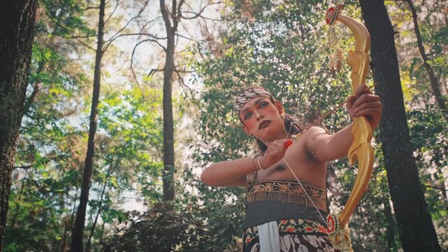 Traditional Javanese Archer Aiming Bow in a Forest
