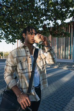 Young man drinking coffee in urban street