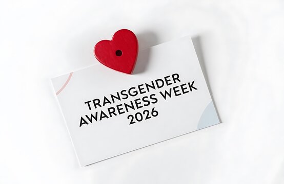 Red heart shape pinned to white paper note with text about transgender awareness week rights social justice campaign human color background studio lightin