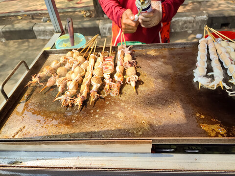 Grilled Squid Skewers on Hot Griddle at Indonesian Street Food Stall