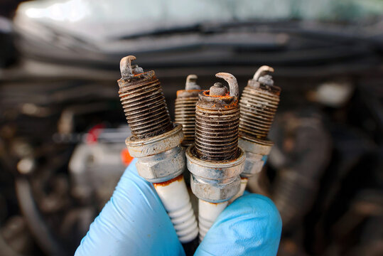 Damaged spark plugs removed from car engine, carbon deposits and rust, poor ignition performance, increased fuel consumption, engine misfires in winter season. Worn out spark plugs. Selective focus