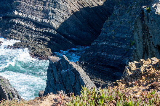 Rugged Coastal Cliffs with Crashing Waves and Sunlight