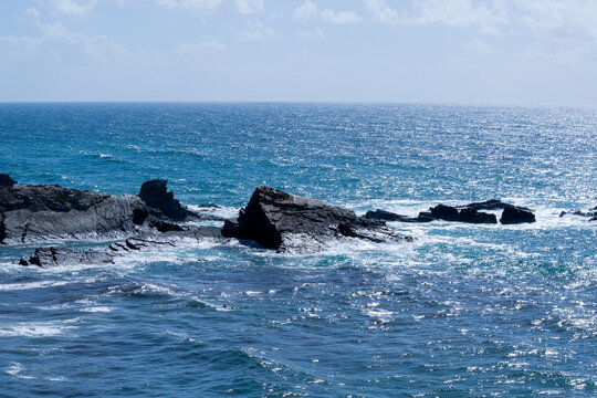 Rugged Coastal Landscape with Crashing Waves and Dark Rocks