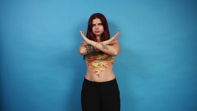 Determined young woman gesturing stop crossing arms