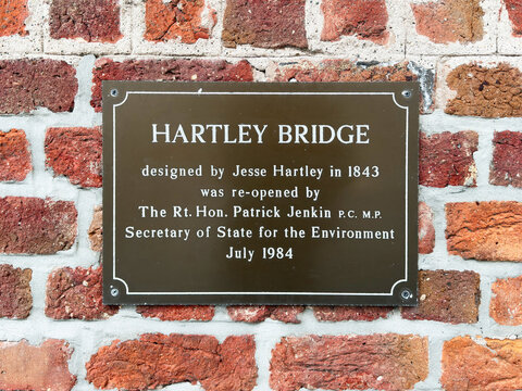 Hartley Bridge plaque on historic brick wall in Liverpool, UK commemorating 1843 design and 1984 reopening