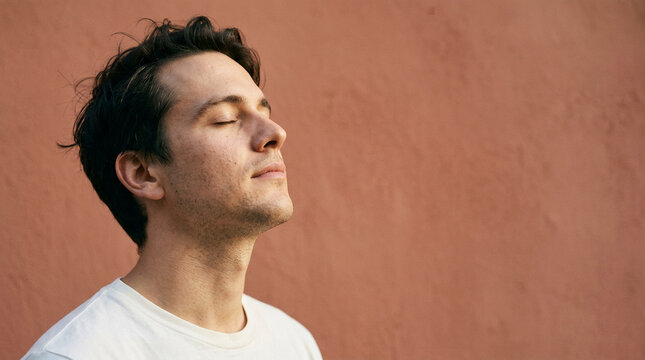 Young man finds peace and tranquility in a moment of mindful reflection, focusing on his breathing for improved mental health and well-being