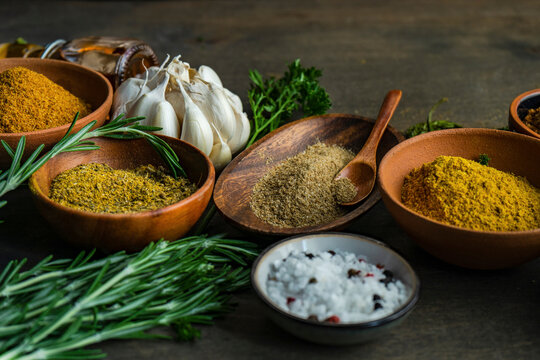 Wooden bowls hold various georgian spices and herbs alongside garlic