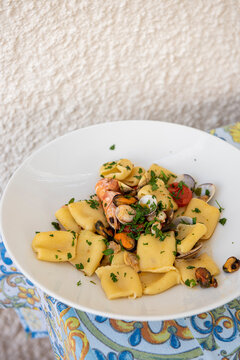 Sicilian paccheri pasta with mixed seafood on a white plate