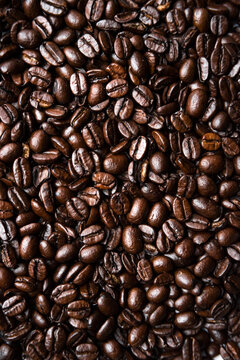 Roasted coffee beans create a textured overhead background