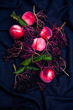 Elderberries and peaches on dark background