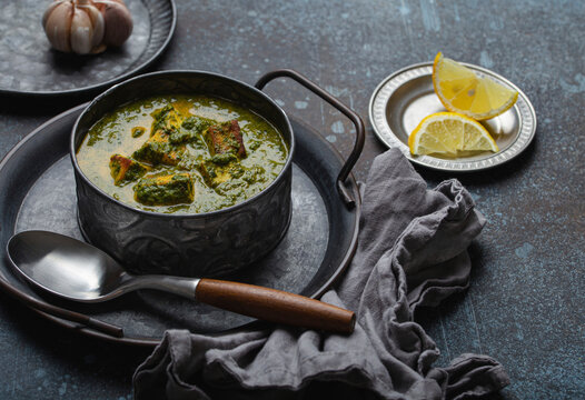 Vegetarian palak paneer with spinach and cheese in vintage metal bowl