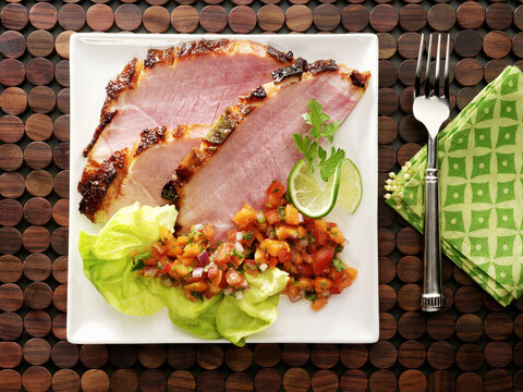 Honey mustard glazed ham slices with chopped tomato salad