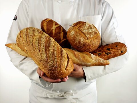 Baker holding a variety of artisan breads