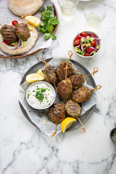 Lamb kofta skewers with tzatziki and pita bread with salad