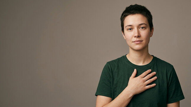 A contemplative young person places a hand over their heart, symbolizing profound honesty and empathy, emphasizing the crucial journey towards improved mental health