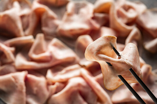 Charcuterie platter with sliced meat held on fork
