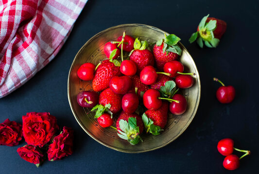 Cherries and strawberries on a gold plate