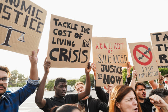 Crowd of multiracial people protest against inflation and financial crisis - Protesters marching for rise cost of living - Main focus on african guy face - UGC content
