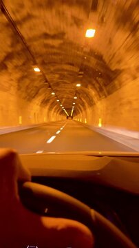 A car travels along a road at night and enters a tunnel. The route runs from Nice, France, towards Genoa, Italy.