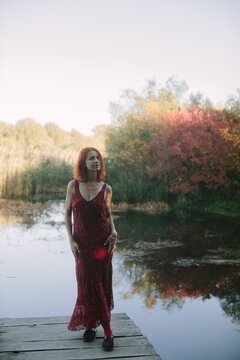 Woman standing on pier reflecting autumn nature